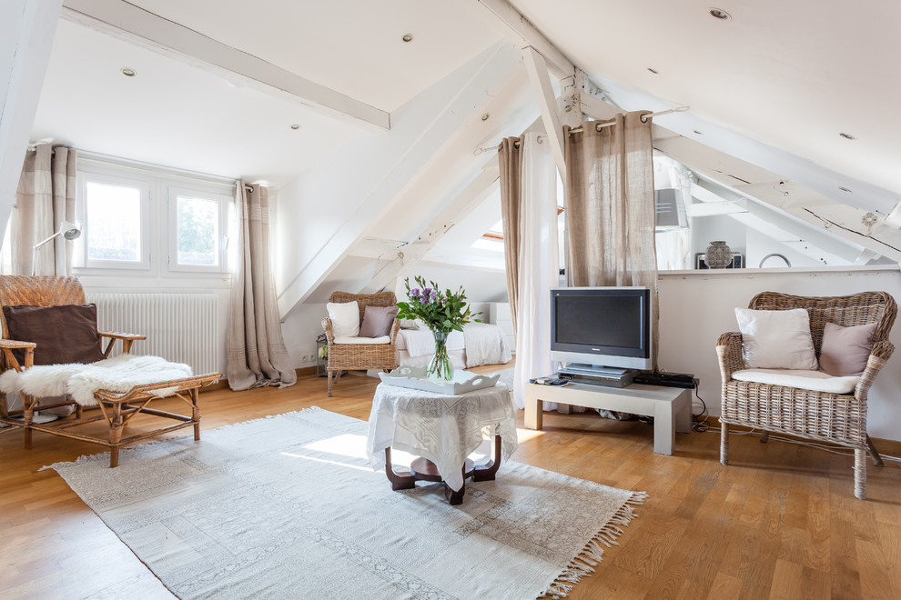 Island style loft-style medium tone wood floor and brown floor living room photo in Paris with white walls and a tv stand