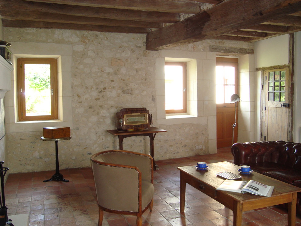 Mittelgroße, Abgetrennte Country Bibliothek mit beiger Wandfarbe, Terrakottaboden, orangem Boden und Kamin in Angers