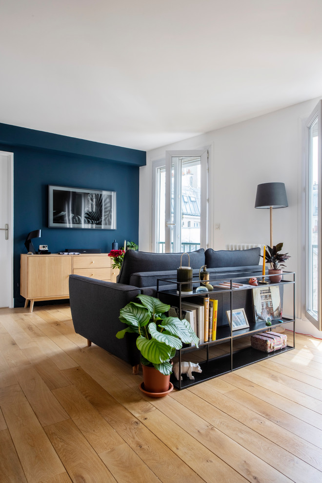 Пример оригинального дизайна: открытая гостиная комната среднего размера в скандинавском стиле с синими стенами, светлым паркетным полом и бежевым полом без камина, телевизора