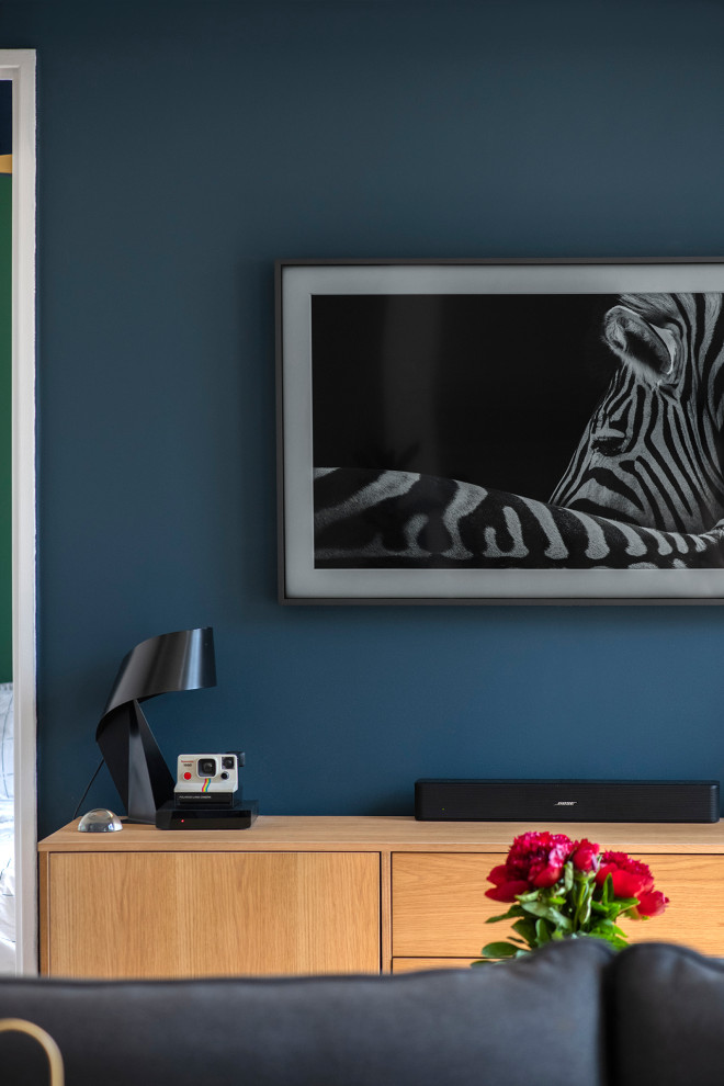 Foto de salón abierto escandinavo de tamaño medio sin chimenea y televisor con paredes azules, suelo de madera clara y suelo beige