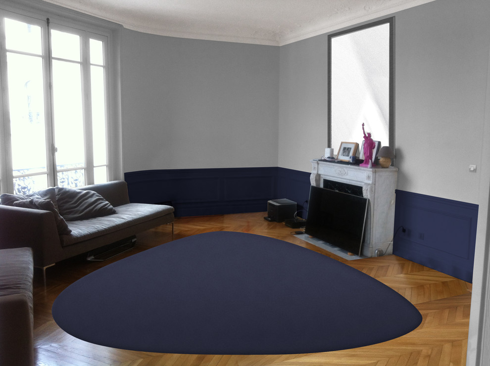 Cette image montre un grand salon design ouvert avec un mur bleu et parquet clair.