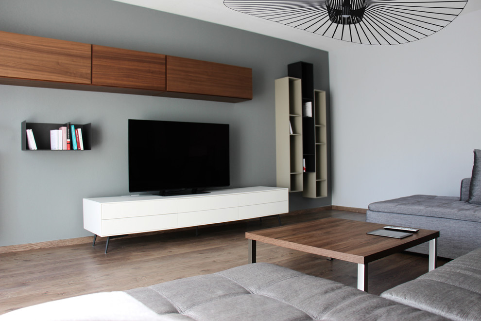 Mittelgroßes Modernes Wohnzimmer ohne Kamin mit grauer Wandfarbe, braunem Holzboden und braunem Boden in Bordeaux