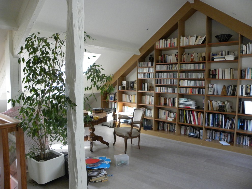 Esempio di un grande soggiorno chic aperto con libreria, pareti bianche e pavimento in laminato