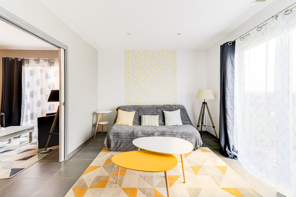 Immagine di un soggiorno nordico di medie dimensioni e chiuso con pareti beige, pavimento con piastrelle in ceramica, nessun camino, TV autoportante e pavimento grigio