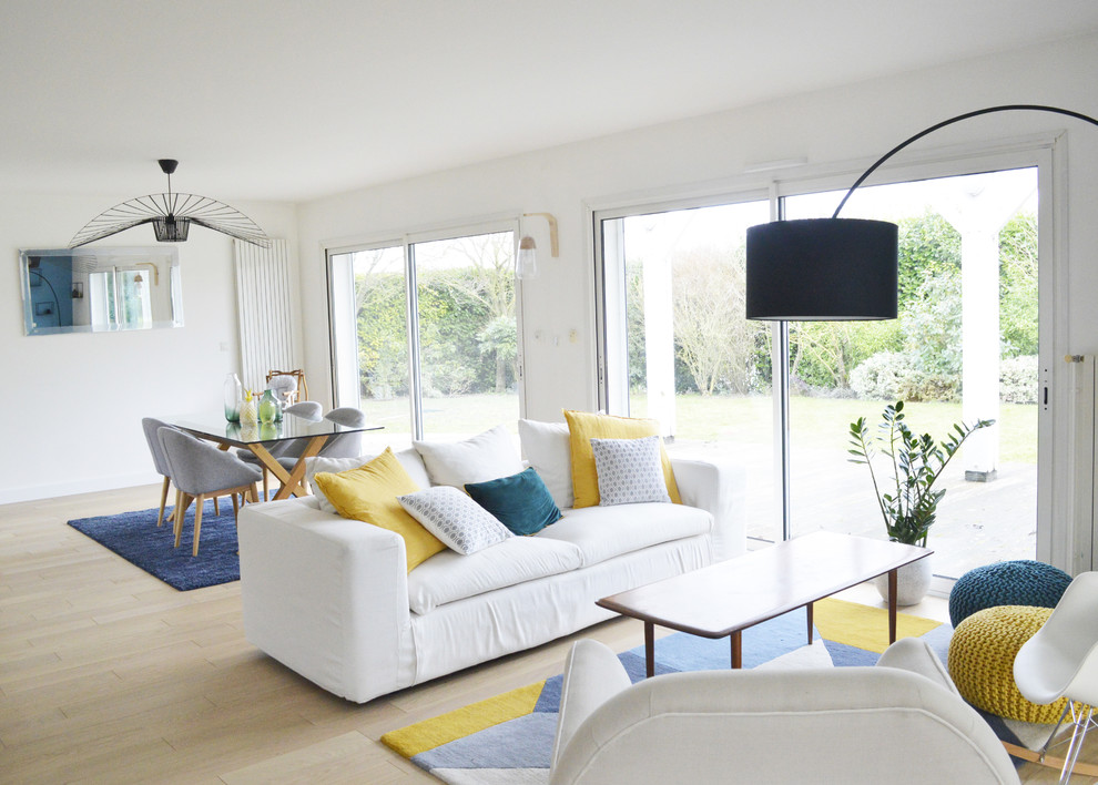 Cette photo montre un salon tendance de taille moyenne et ouvert avec un mur blanc, parquet clair et un sol beige.