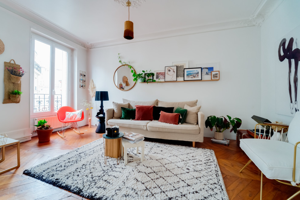 Immagine di un soggiorno eclettico di medie dimensioni con pareti bianche, pavimento in legno massello medio e pavimento marrone