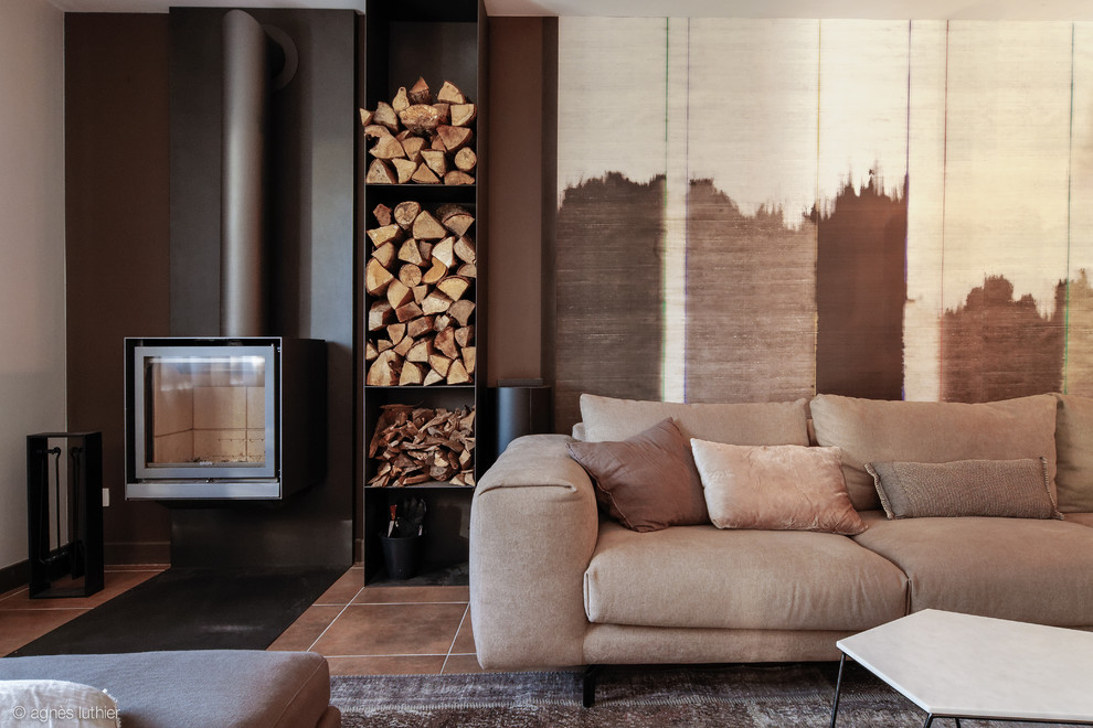 Inspiration for a large bohemian enclosed living room in Montpellier with brown walls, ceramic flooring, a wood burning stove, a metal fireplace surround and a concealed tv.