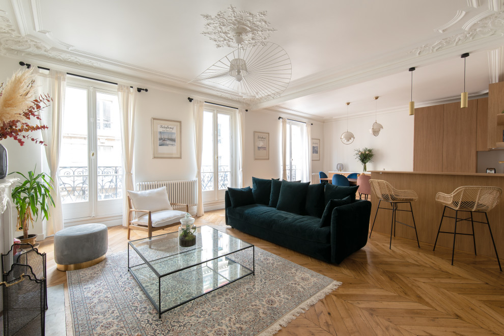 Großes, Fernseherloses, Offenes Klassisches Wohnzimmer mit weißer Wandfarbe, braunem Holzboden, Kamin, verputzter Kaminumrandung und braunem Boden in Paris