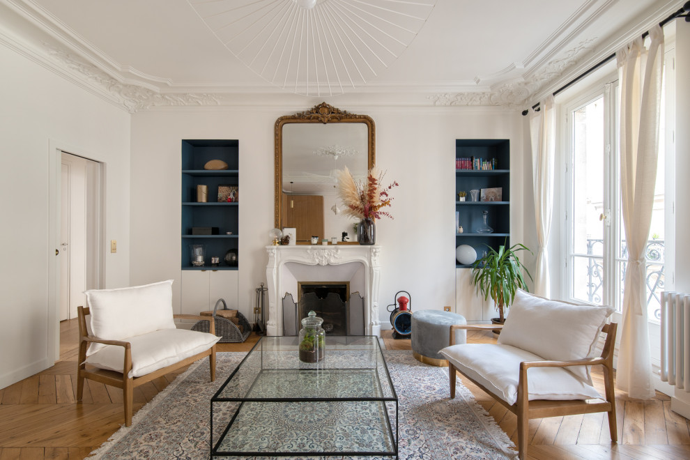 Inspiration pour un grand salon design ouvert avec un mur blanc, un sol en bois brun, une cheminée standard, un manteau de cheminée en plâtre, aucun téléviseur et un sol marron.