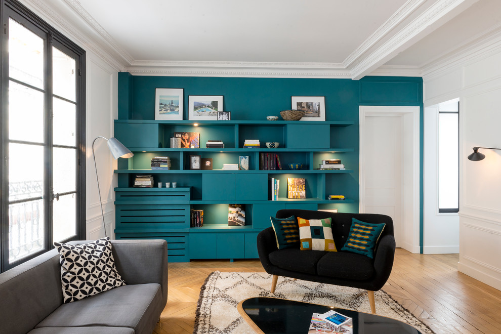 パリにある高級な広いコンテンポラリースタイルのおしゃれな独立型リビング (暖炉なし、テレビなし、淡色無垢フローリング、青い壁、黒いソファ) の写真