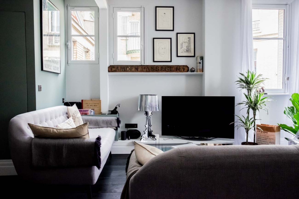 Idéer för mellanstora funkis allrum med öppen planlösning, med en fristående TV, blå väggar, målat trägolv och svart golv