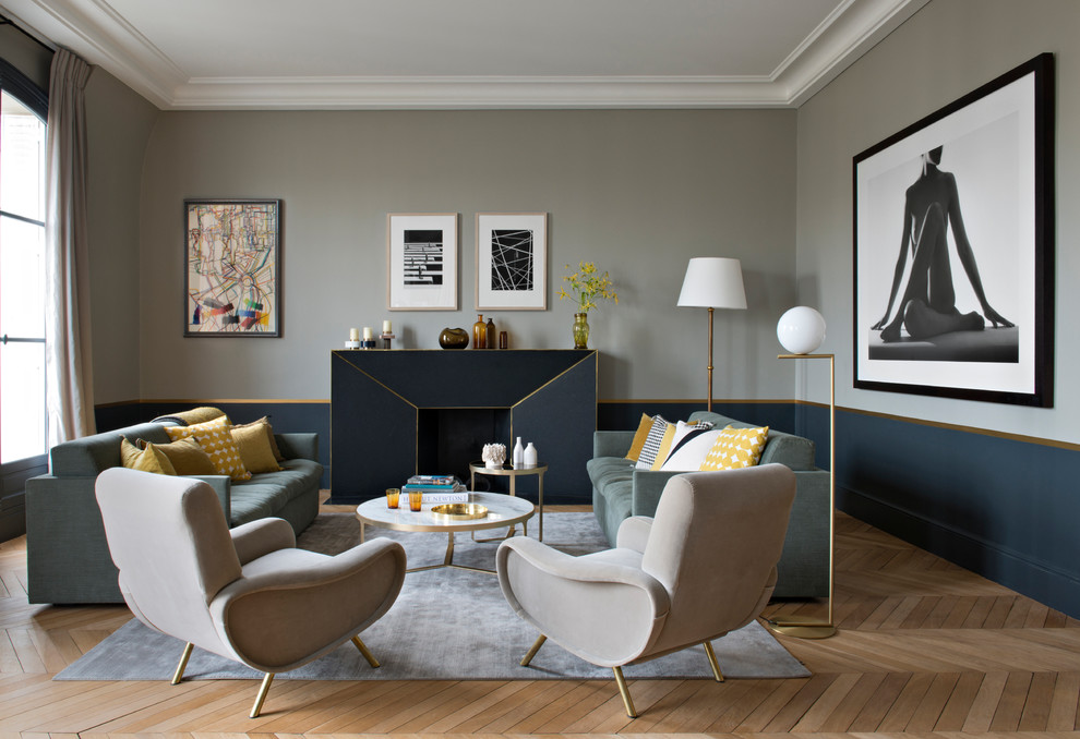 Стильный дизайн: гостиная комната:: освещение в стиле неоклассика (современная классика) с серыми стенами, паркетным полом среднего тона, стандартным камином и коричневым полом - последний тренд