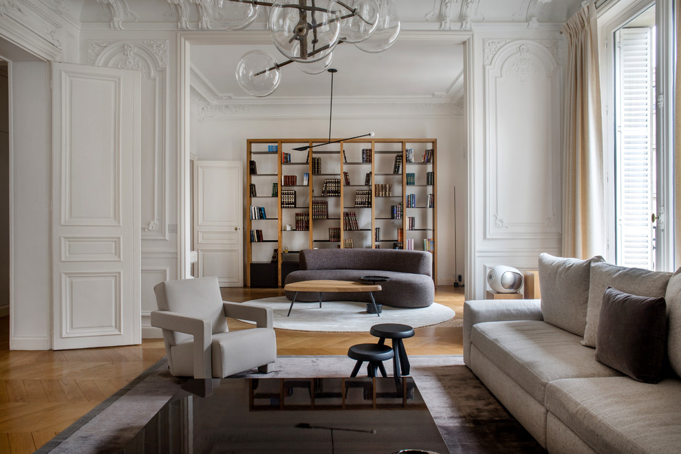 Example of a trendy enclosed medium tone wood floor and brown floor living room design in Paris with white walls