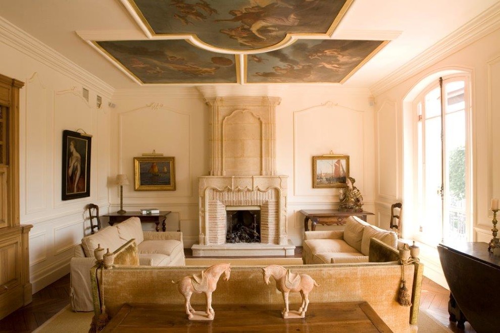 Example of a large transitional enclosed medium tone wood floor living room design in Paris with white walls, a standard fireplace, a stone fireplace and no tv
