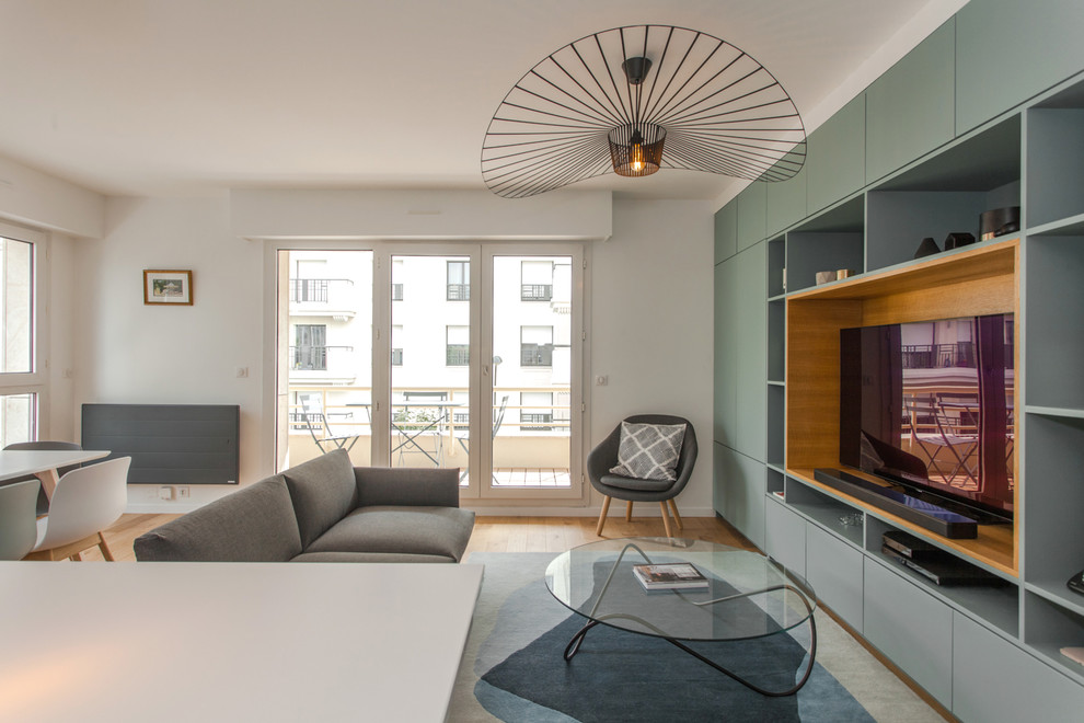 На фото: открытая гостиная комната в современном стиле с белыми стенами, отдельно стоящим телевизором, паркетным полом среднего тона и коричневым полом без камина