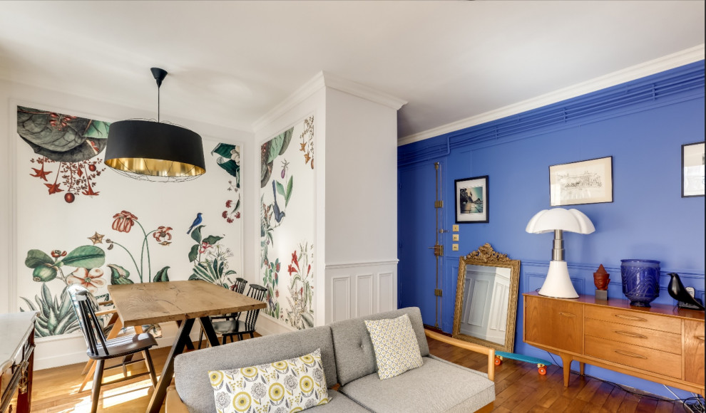 Eklektisk inredning av ett vardagsrum, med blå väggar, mellanmörkt trägolv och brunt golv
