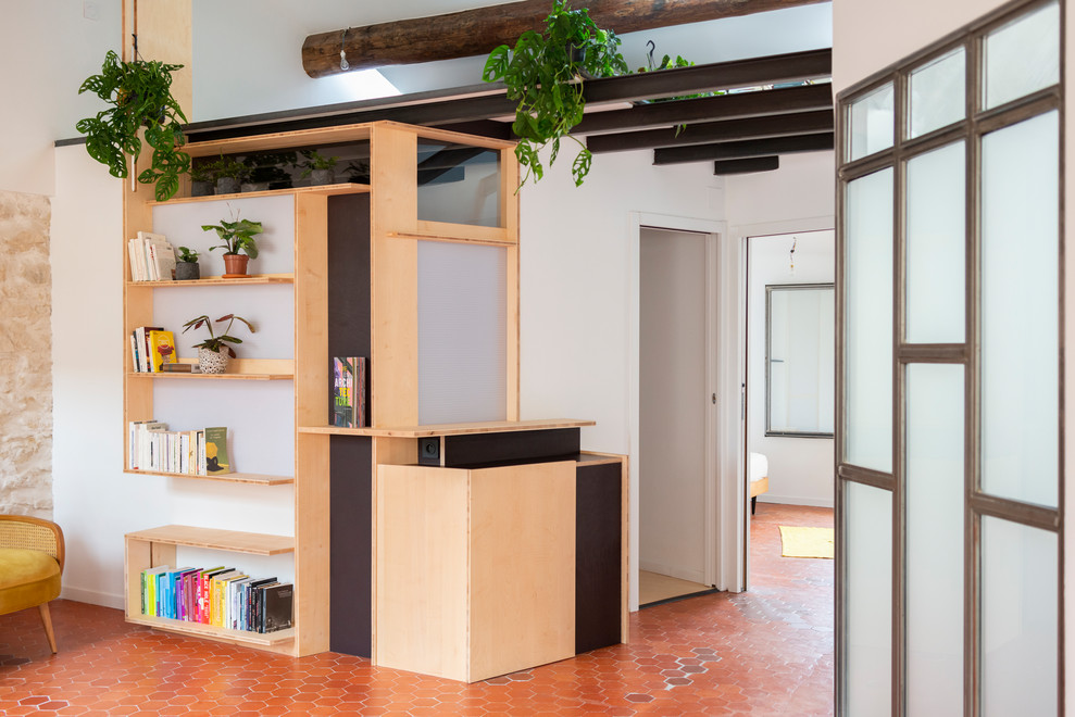 На фото: маленькая открытая гостиная комната в современном стиле с с книжными шкафами и полками, белыми стенами и полом из терракотовой плитки для на участке и в саду