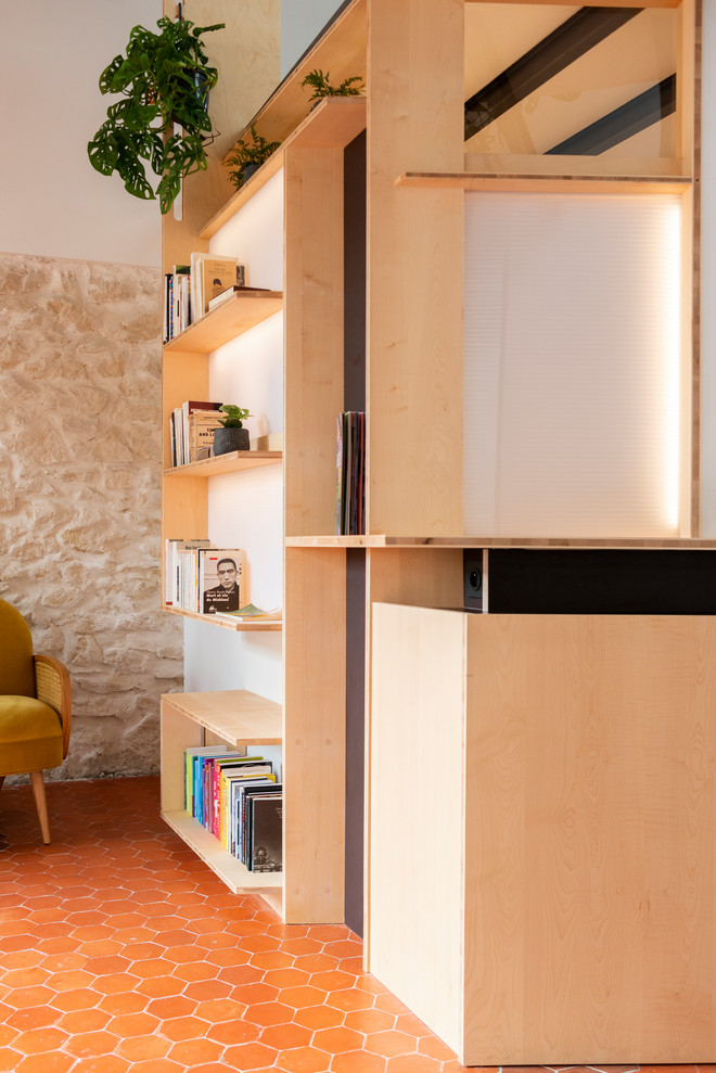 Idee per un piccolo soggiorno design aperto con libreria, pareti bianche e pavimento in terracotta