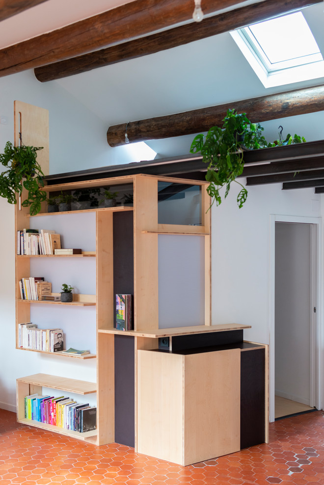Diseño de biblioteca en casa abierta actual pequeña con paredes blancas, suelo de baldosas de terracota y suelo rojo