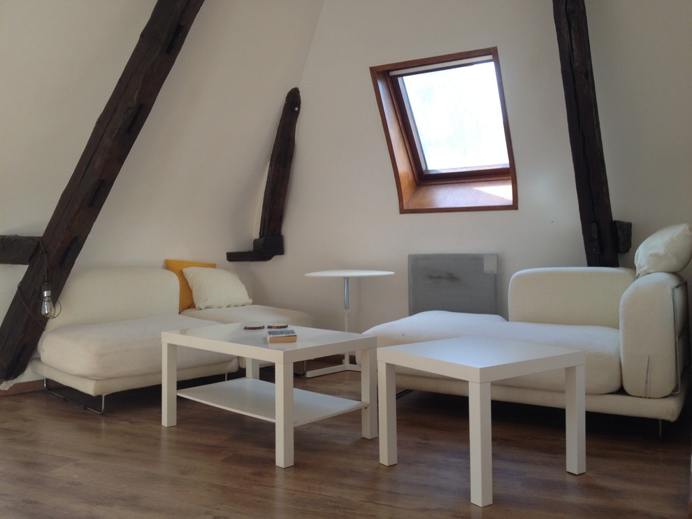 Immagine di un piccolo soggiorno contemporaneo aperto con libreria, pareti bianche e pavimento in laminato