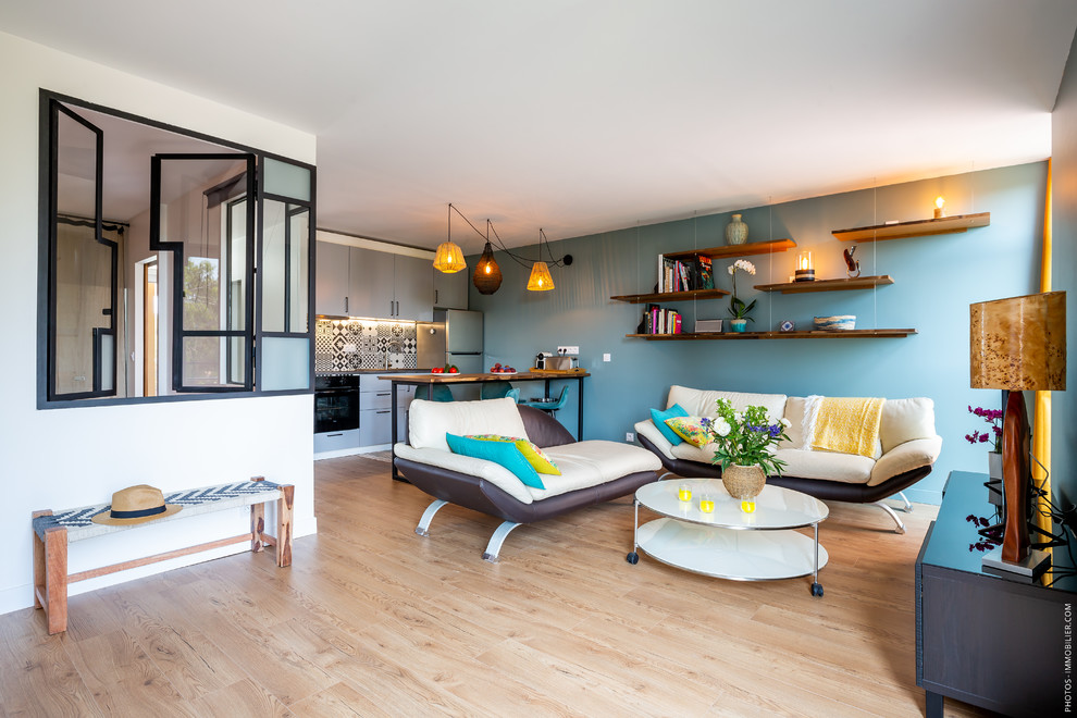 Exemple d'un salon tendance ouvert avec un mur bleu, un sol en bois brun, un téléviseur indépendant et un sol beige.