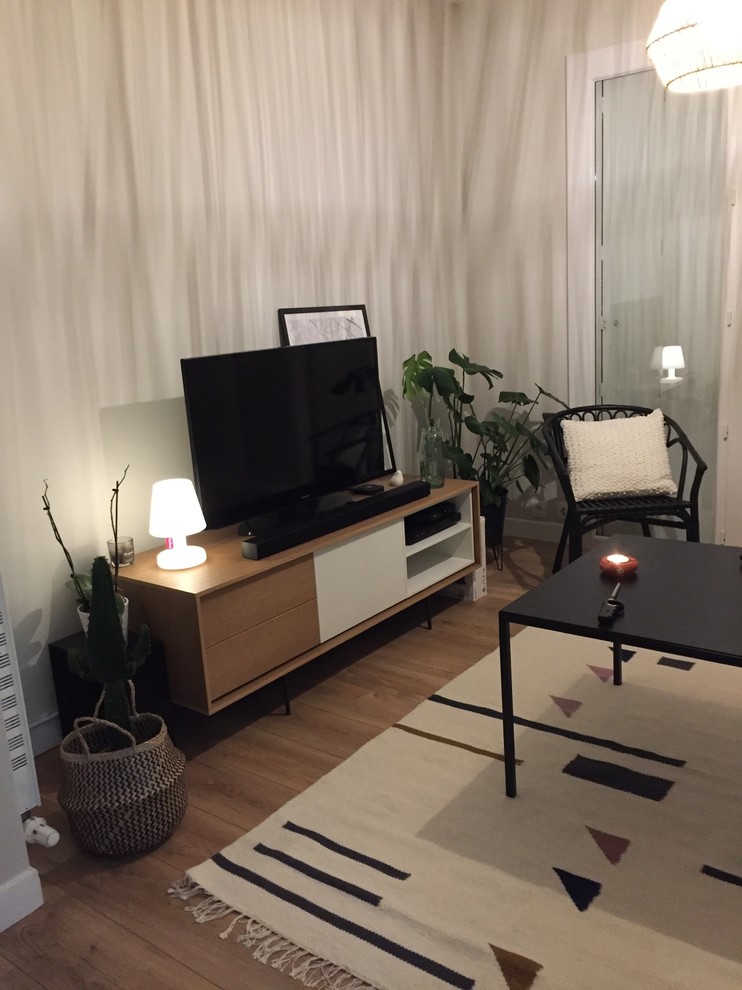 Diseño de salón abierto contemporáneo pequeño sin chimenea con paredes blancas, suelo de madera clara, televisor independiente y suelo marrón