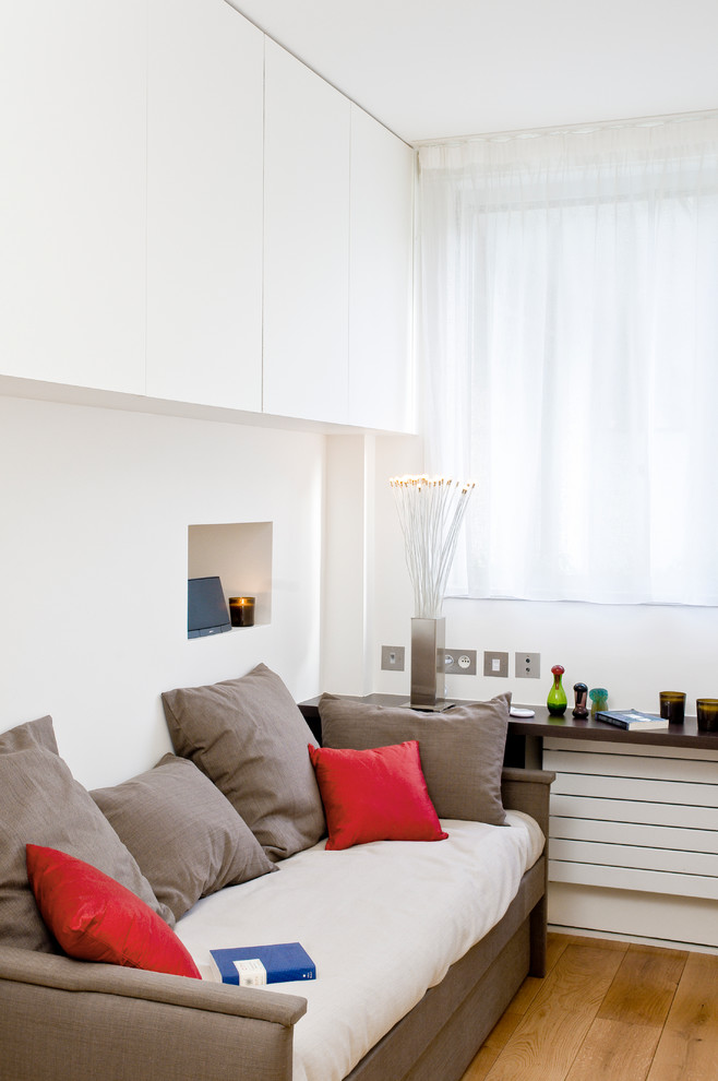 Стильный дизайн: гостиная комната в современном стиле с белыми стенами и паркетным полом среднего тона - последний тренд