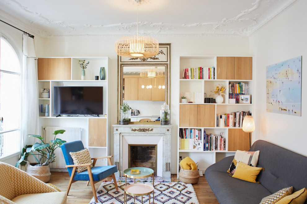Mittelgroßes Eklektisches Wohnzimmer mit weißer Wandfarbe, braunem Holzboden, Kamin, freistehendem TV und braunem Boden in Paris