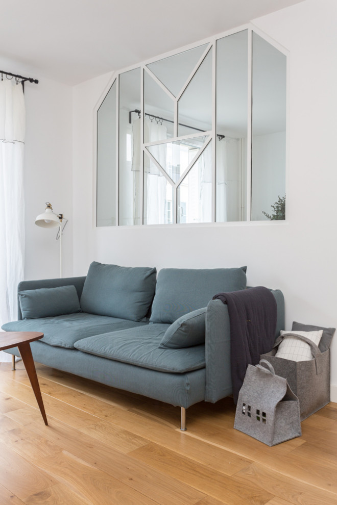 Mittelgroßes, Offenes Skandinavisches Wohnzimmer ohne Kamin mit weißer Wandfarbe, hellem Holzboden, verstecktem TV und beigem Boden in Paris