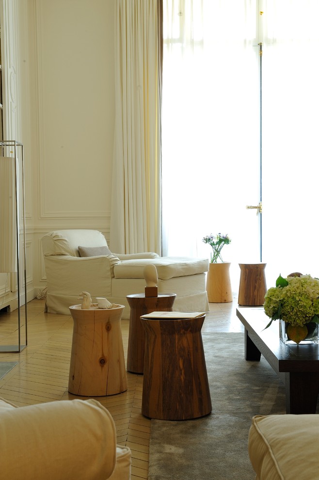 Esempio di un soggiorno eclettico di medie dimensioni e chiuso con pareti bianche, parquet chiaro, libreria e pavimento beige