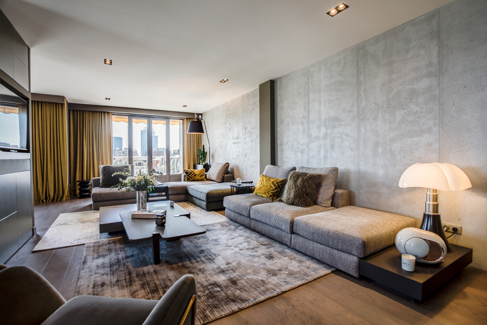 Exemple d'un salon tendance ouvert avec un mur gris, un sol en bois brun, un téléviseur encastré, un sol marron et éclairage.