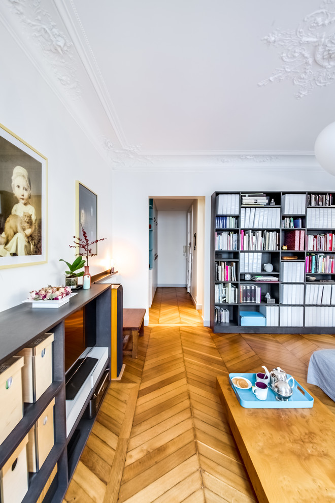 Mittelgroße, Offene Moderne Bibliothek ohne Kamin mit weißer Wandfarbe, hellem Holzboden und freistehendem TV in Paris