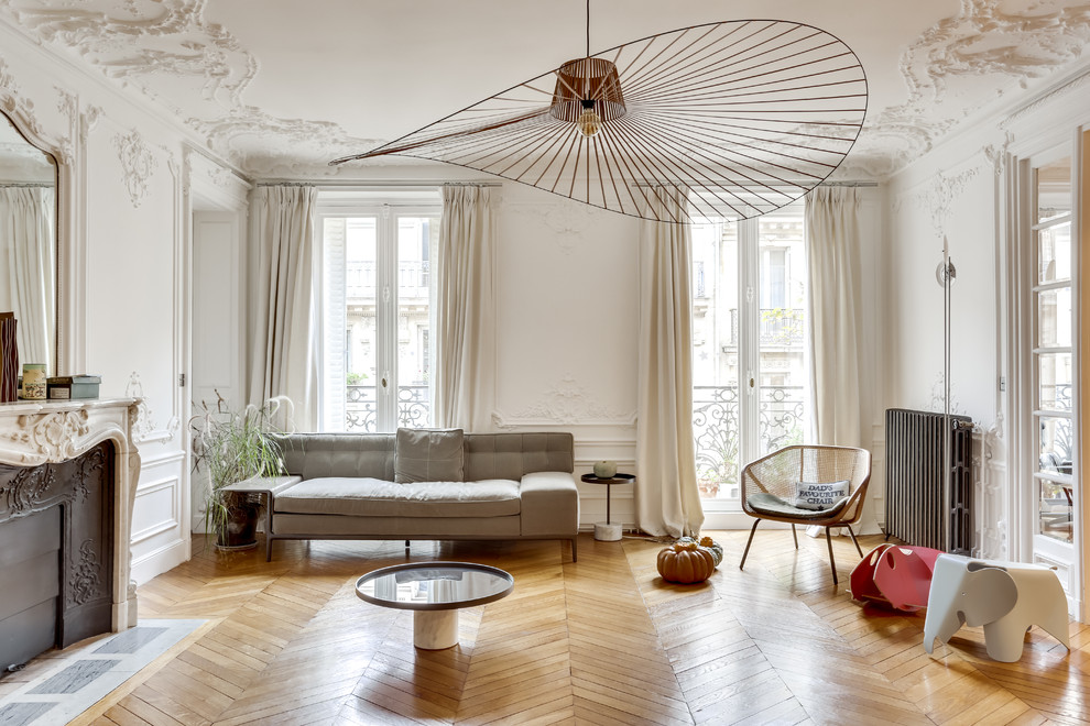 Imagen de salón escandinavo sin televisor con paredes blancas, suelo de madera en tonos medios y todas las chimeneas