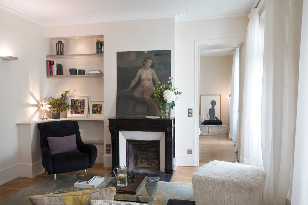 パリにあるお手頃価格の広いトランジショナルスタイルのおしゃれなLDK (ベージュの壁、淡色無垢フローリング、標準型暖炉、石材の暖炉まわり、茶色い床) の写真