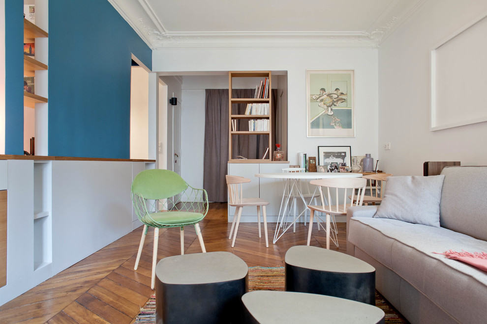 Esempio di un soggiorno minimal aperto con libreria, pareti bianche, parquet scuro e pavimento marrone