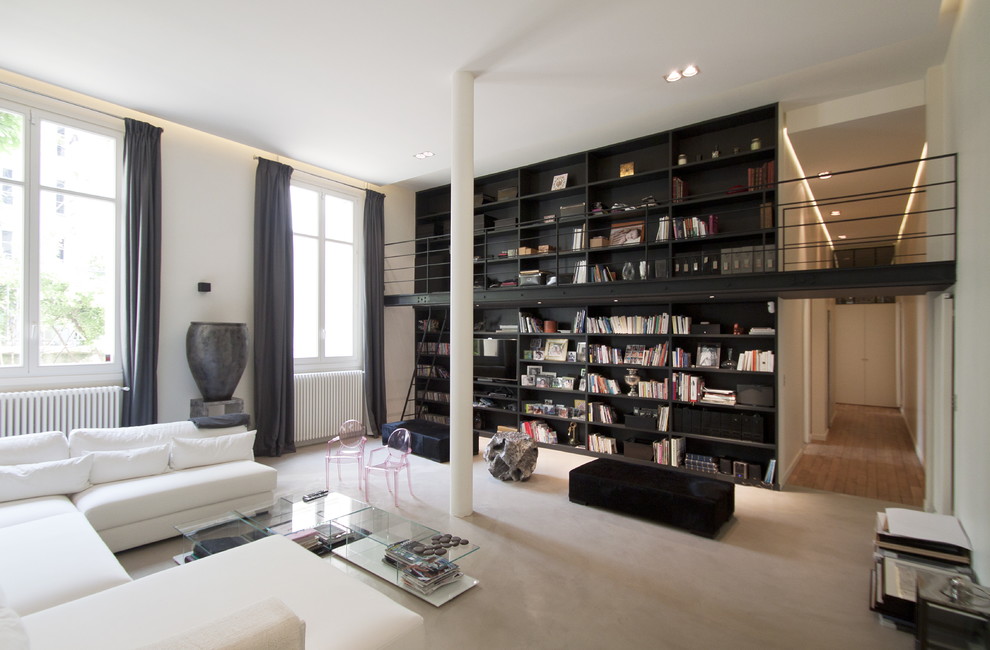 Cette image montre un grand salon design ouvert avec une bibliothèque ou un coin lecture, un mur blanc, moquette et aucune cheminée.