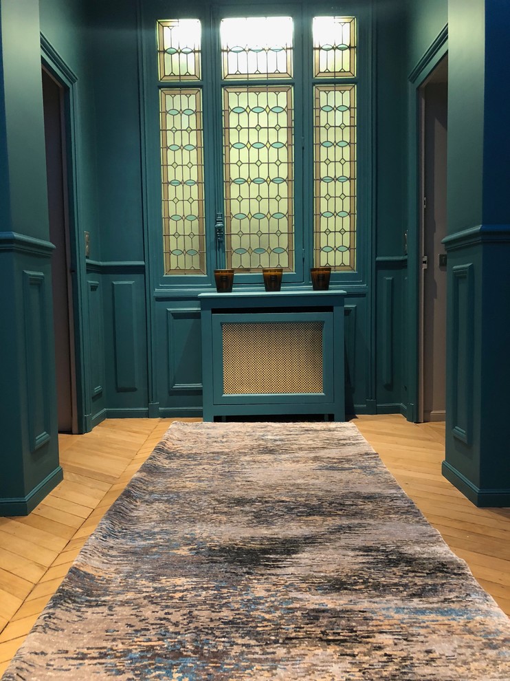 Aménagement d'un grand salon contemporain fermé avec un mur bleu, parquet clair et un sol beige.