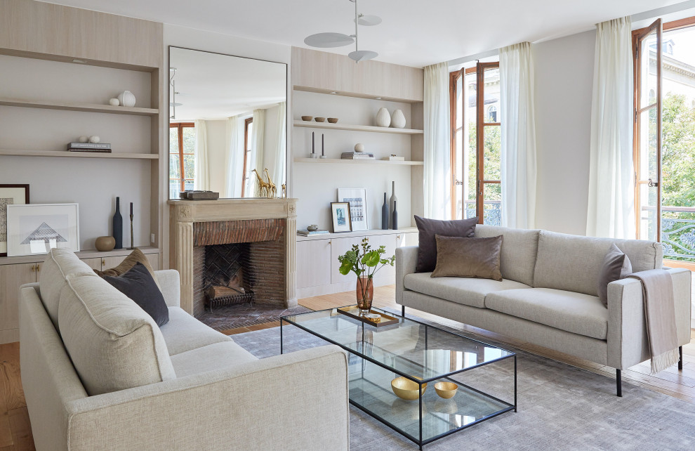 Repräsentatives, Fernseherloses, Offenes Modernes Wohnzimmer mit hellem Holzboden, Kamin und grauer Wandfarbe in Paris