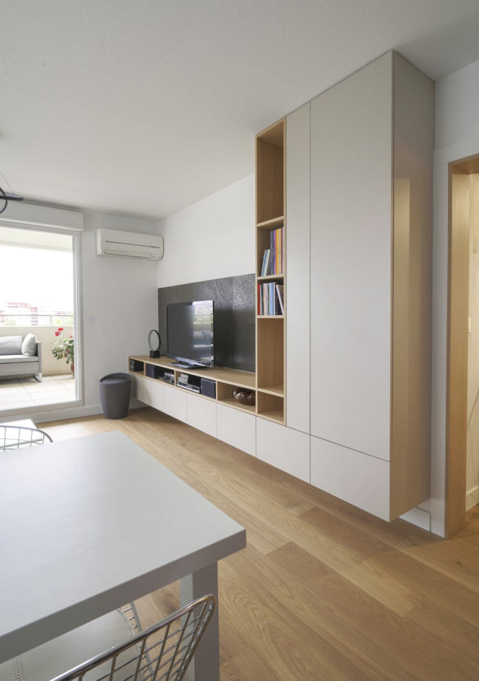 Foto de salón abierto moderno de tamaño medio con paredes blancas, suelo de madera clara y suelo marrón
