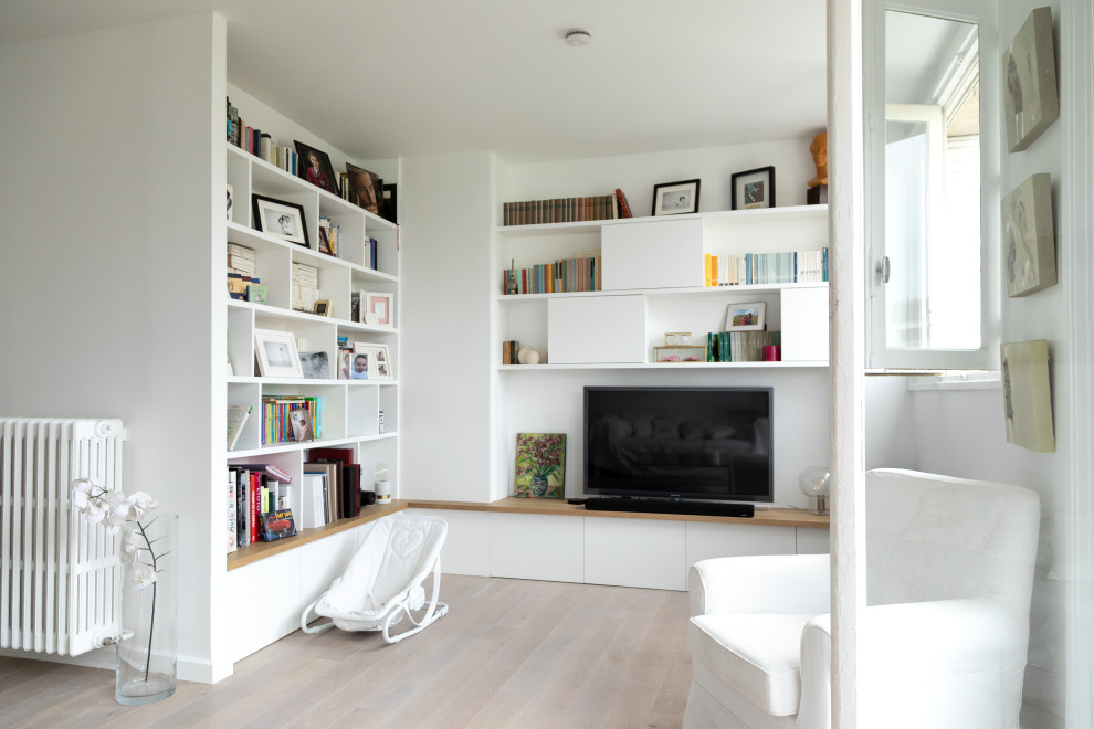 Inspiration pour un salon minimaliste de taille moyenne et ouvert avec une bibliothèque ou un coin lecture, un mur blanc, parquet clair, aucune cheminée, un téléviseur indépendant et un sol beige.