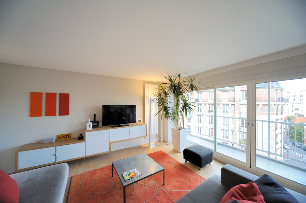 Mittelgroßes, Abgetrenntes Modernes Wohnzimmer ohne Kamin mit weißer Wandfarbe, hellem Holzboden und freistehendem TV in Paris