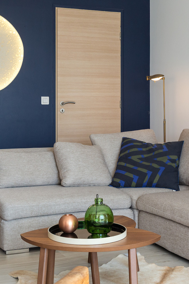 Esempio di un soggiorno minimal di medie dimensioni e chiuso con pareti blu, pavimento con piastrelle in ceramica, libreria, nessun camino e nessuna TV