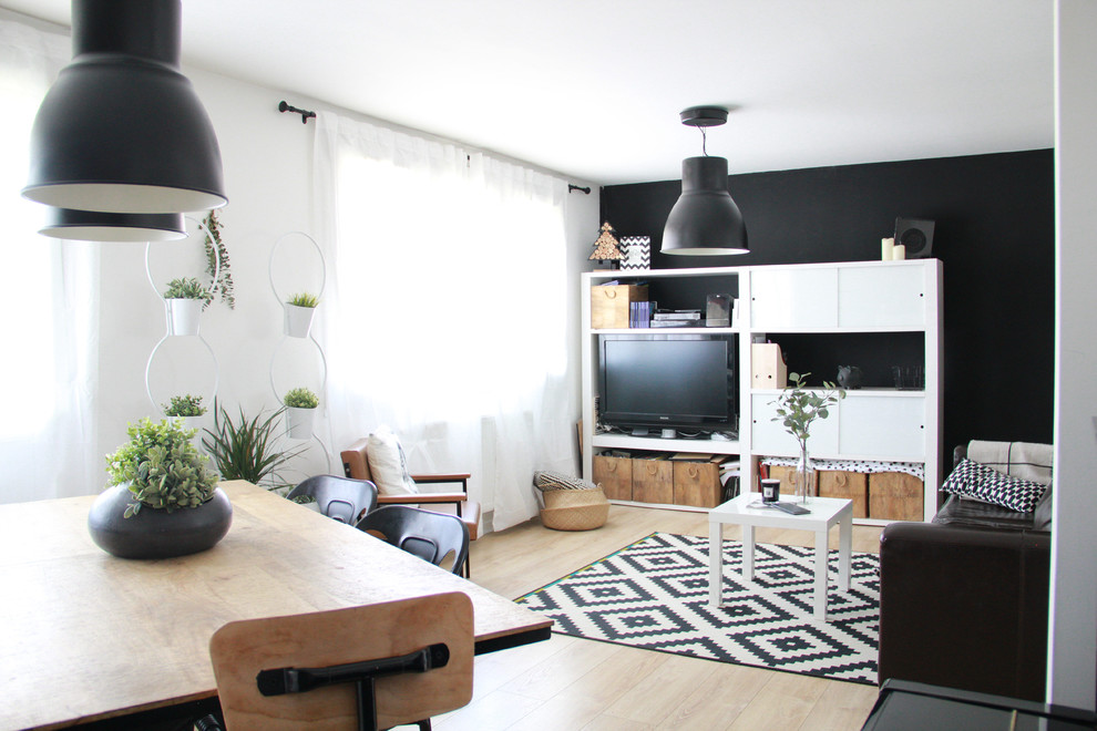Пример оригинального дизайна: изолированная гостиная комната среднего размера в современном стиле с с книжными шкафами и полками, черными стенами, светлым паркетным полом, отдельно стоящим телевизором и коричневым полом