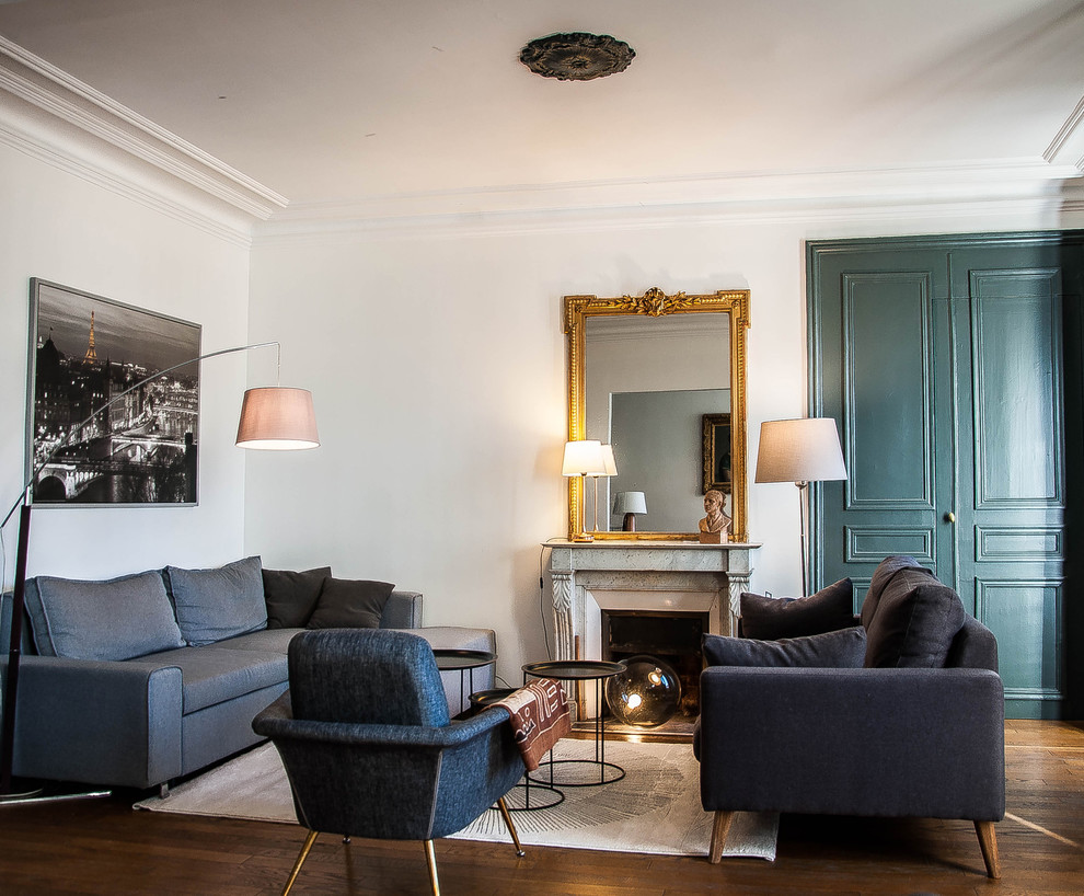 Repräsentatives, Fernseherloses, Offenes, Mittelgroßes Klassisches Wohnzimmer mit weißer Wandfarbe, dunklem Holzboden, Kamin und Kaminumrandung aus Stein in Paris