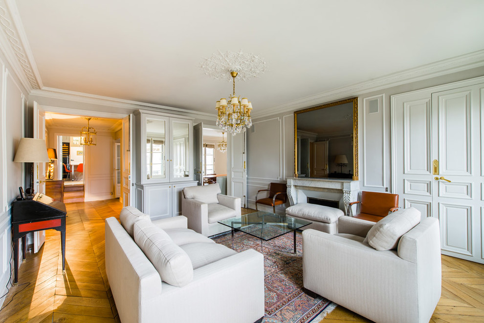 Foto di un grande soggiorno chic chiuso con pareti bianche, pavimento in legno massello medio, camino classico, sala formale e nessuna TV