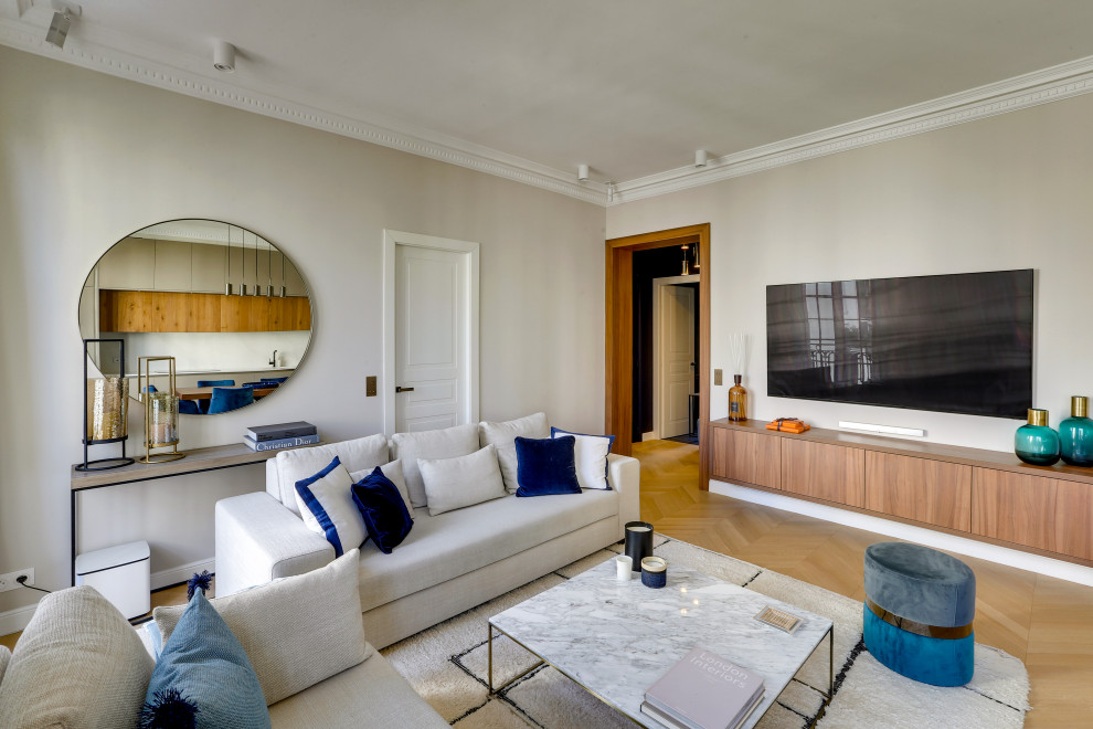 Esempio di un soggiorno design chiuso con pareti beige, parquet chiaro, TV a parete e pavimento beige