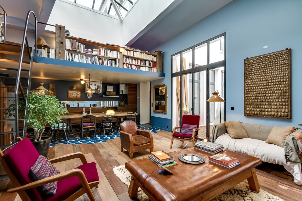 Источник вдохновения для домашнего уюта: открытая гостиная комната среднего размера в стиле фьюжн с с книжными шкафами и полками, синими стенами и паркетным полом среднего тона