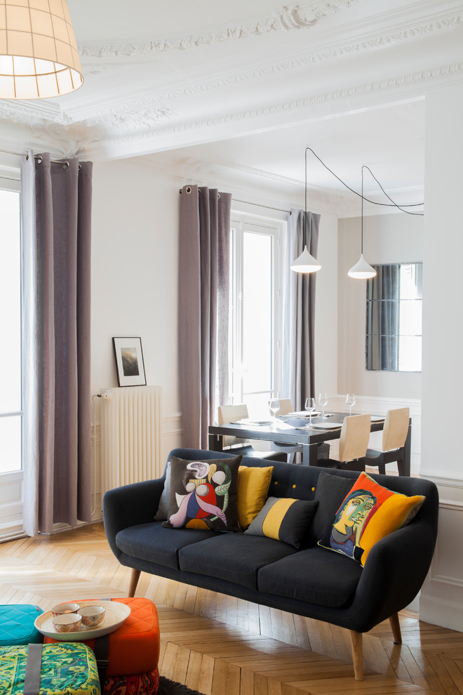 Offenes, Mittelgroßes, Fernseherloses Modernes Wohnzimmer ohne Kamin mit braunem Holzboden und weißer Wandfarbe in Paris