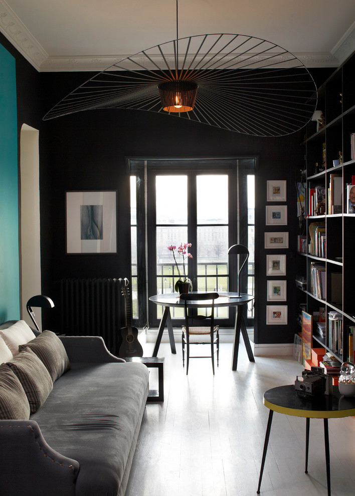 Источник вдохновения для домашнего уюта: изолированная гостиная комната среднего размера в современном стиле с с книжными шкафами и полками, черными стенами и деревянным полом без камина, телевизора