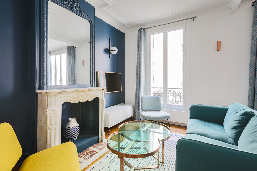 Exemple d'un salon tendance avec un mur bleu, un sol en bois brun, une cheminée standard et un sol marron.